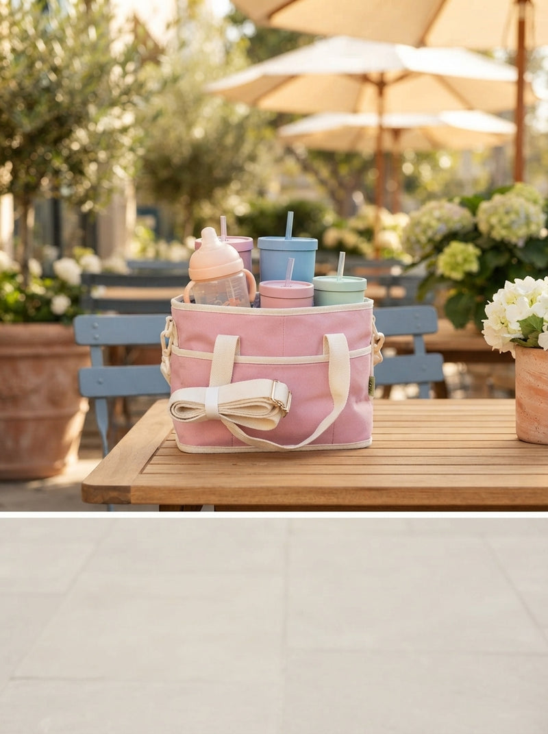 A four-cup drink carrier sitting on a clean surface in a bright, out-of-focus outdoor setting.